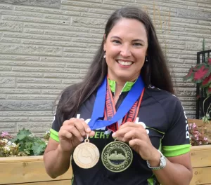 Dr. Sarah Hopkins, chiropractor and OCA member, posing with medals