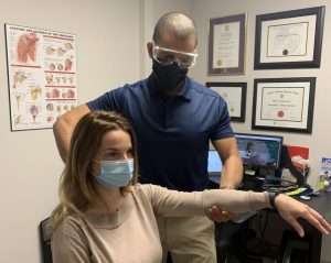 Dr. Gordon-Tennant assessing female patient's arm