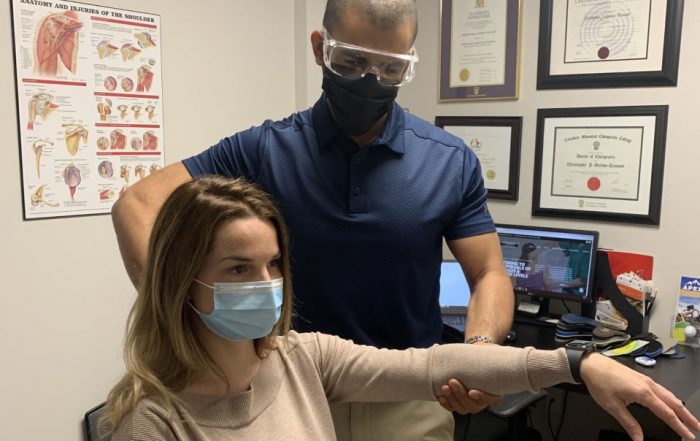 Dr. Gordon-Tennant assessing female patient's arm