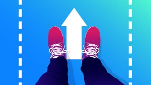 A stock image of a person's feet on the ground, near an arrow pointing up