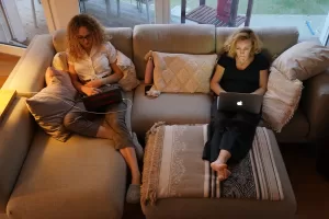 A mother, who is temporarily working from home, and her daughter sit on a couch with their laptops on March 28 in Berlin
