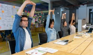 People sitting in a meeting room, stretching