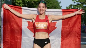 Runner Natasha Wodak holding a Canadian flag