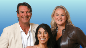 A man and two women posing for a photo in front of a blue background.