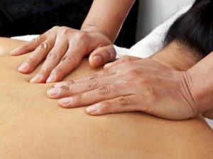 Image of a massage therapist giving a patient a back massage.