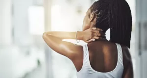 Image of a woman rubbing her neck in pain.